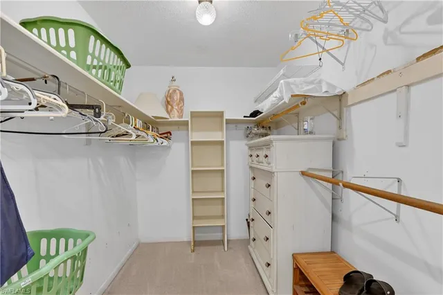 a view of walk in closet with clothes and shoes