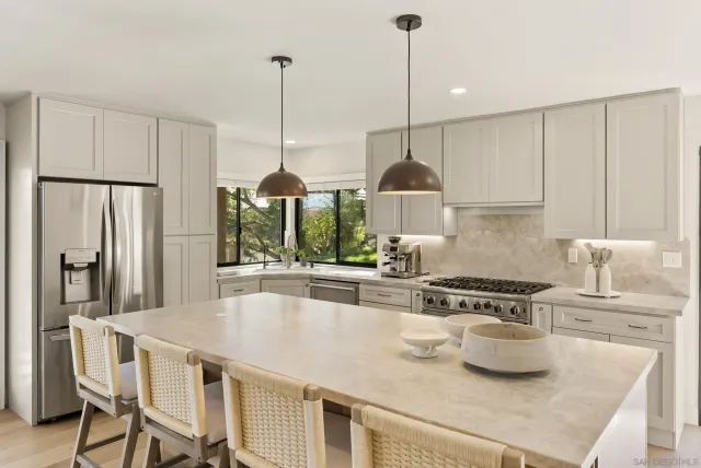 a kitchen with stainless steel appliances granite countertop a sink a stove and a wooden floors