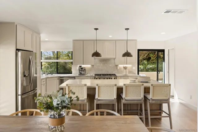 a kitchen with a stove a refrigerator and a dining table
