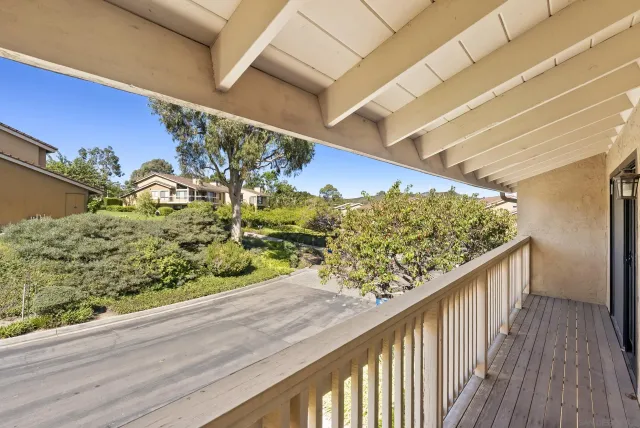 a view of a balcony with wooden floor and fence