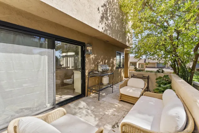 a view of a patio with couches table and chairs and potted plants