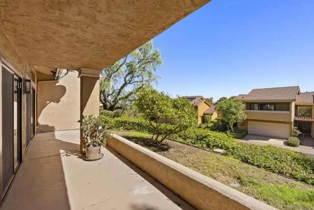 a view of a balcony with wooden floor and a outdoor view