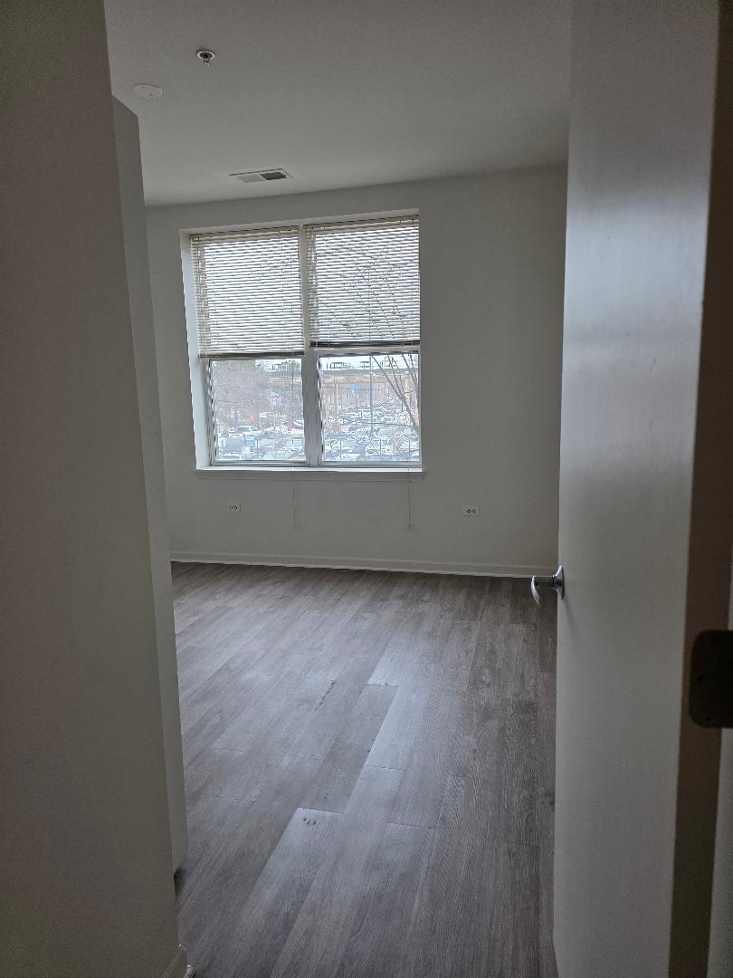 3506 South State Street, Unit 208 Chicago, IL 60609 - Photo 10 of 14 an empty room with a window