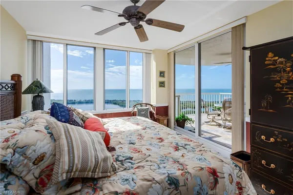 a living room with furniture a flat screen tv and a refrigerator