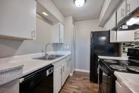 a kitchen with a sink stove and cabinets