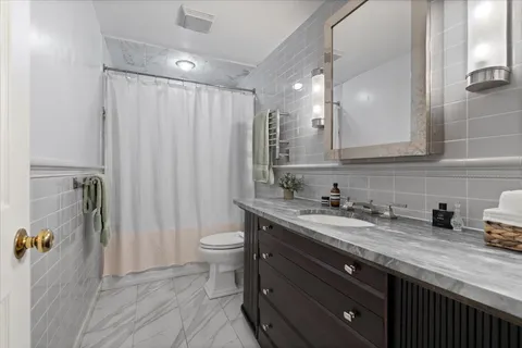 a bathroom with a granite countertop sink toilet and shower