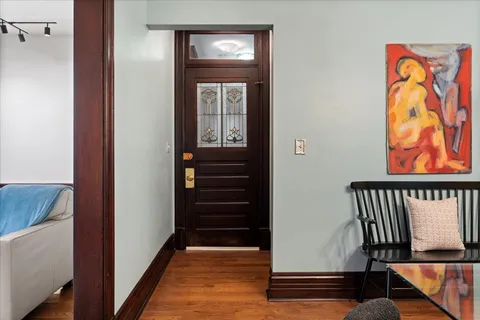 a view of a hallway with wooden floor and stairs