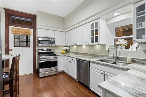 a kitchen with kitchen island granite countertop a stove and a sink