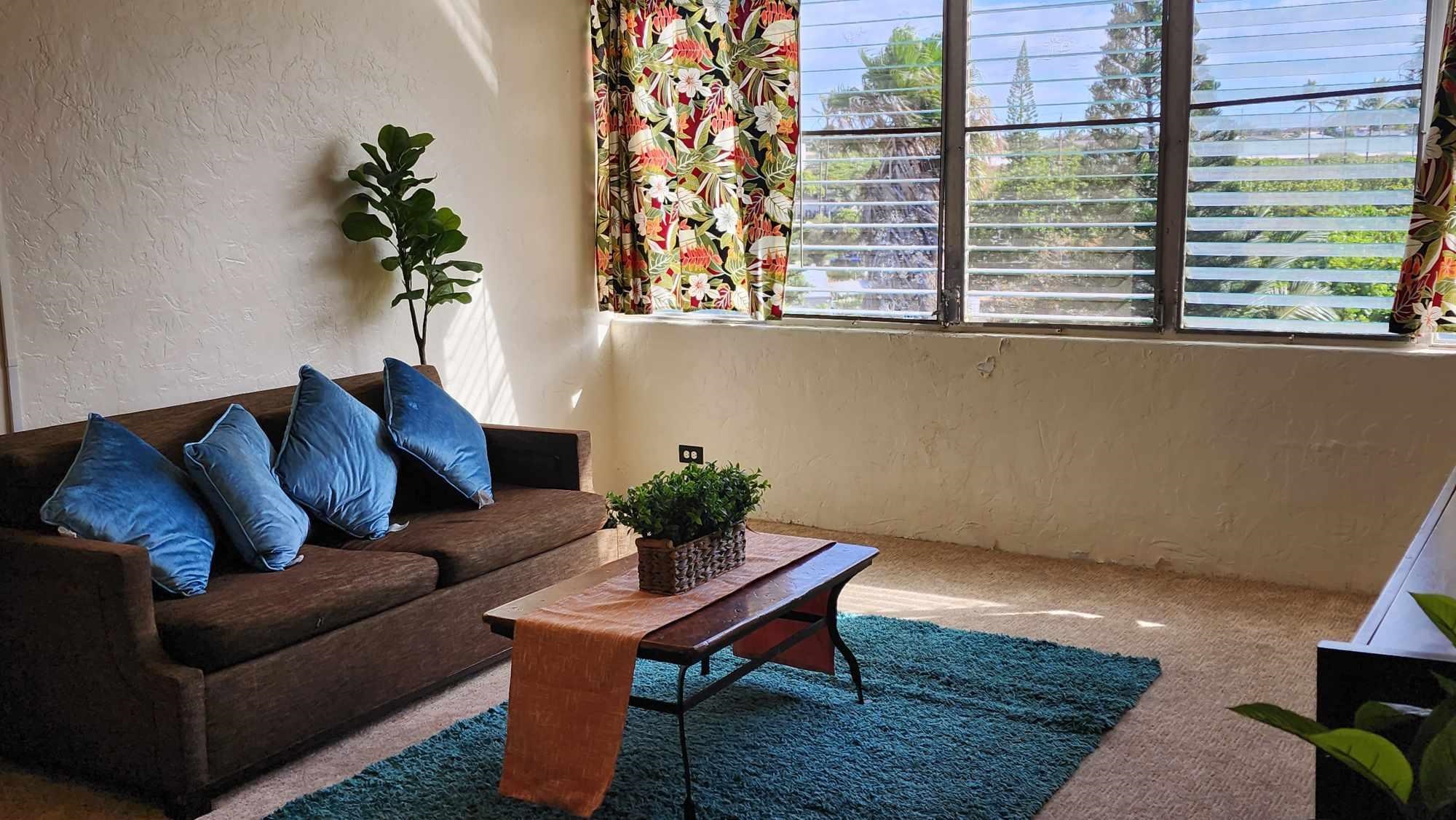 a living room with furniture and a potted plant