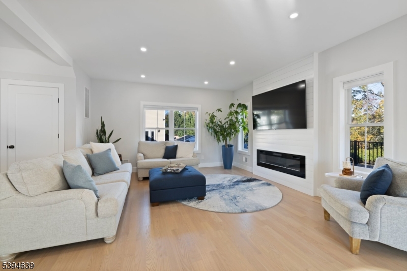 574 Ridgedale Avenue East Hanover, NJ 07936 - Photo 11 of 35 a living room with furniture a fireplace and a flat screen tv