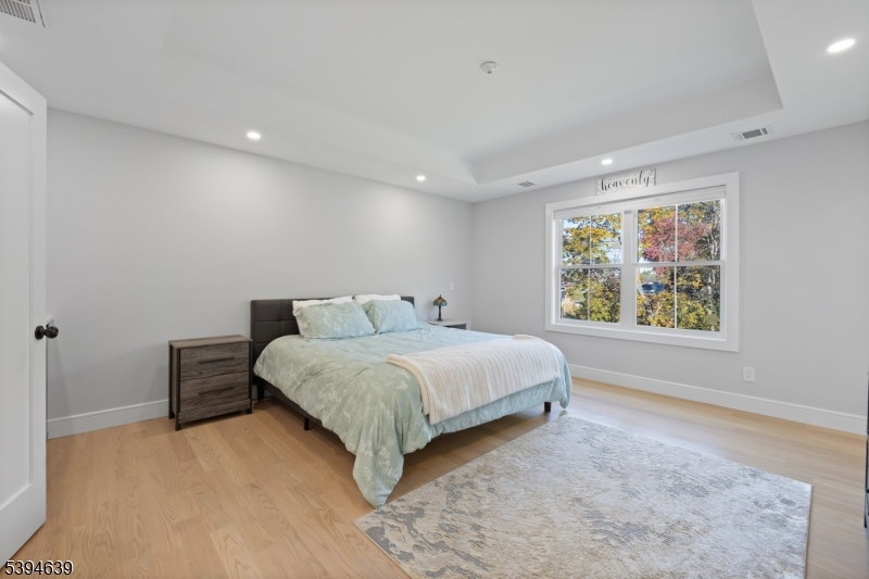 574 Ridgedale Avenue East Hanover, NJ 07936 - Photo 14 of 35 a spacious bedroom with a large bed and a large window