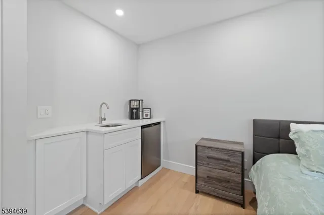 a spacious bedroom with a bed and chair