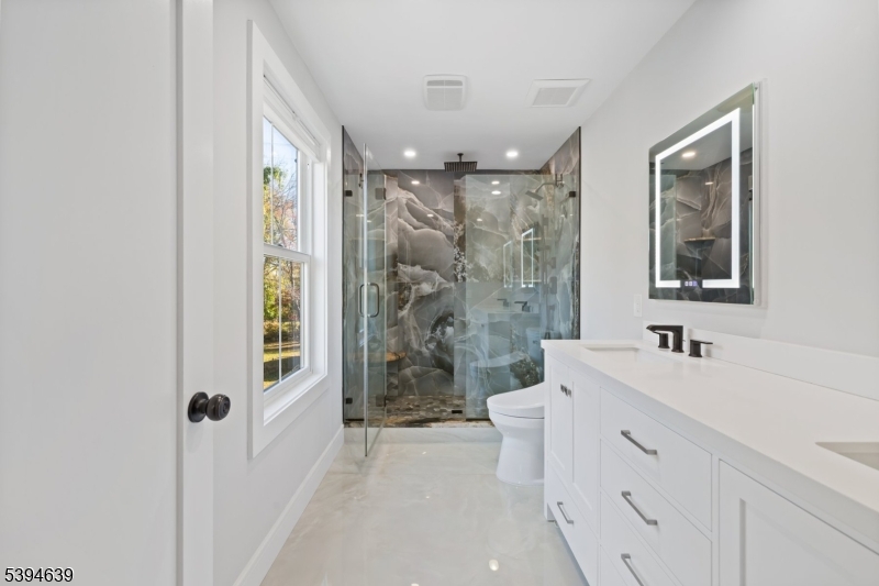 574 Ridgedale Avenue East Hanover, NJ 07936 - Photo 17 of 35 a bathroom with a double vanity sink toilet and shower