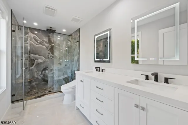 a bathroom with a granite countertop sink toilet and shower
