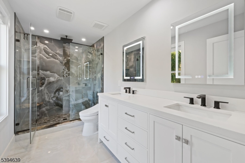 574 Ridgedale Avenue East Hanover, NJ 07936 - Photo 18 of 35 a bathroom with a double vanity sink mirror double shower and toilet