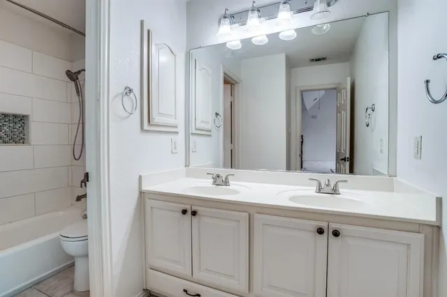 a bathroom with a sink a toilet and a mirror