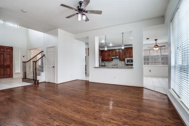 a view of a big room with wooden floor and windows