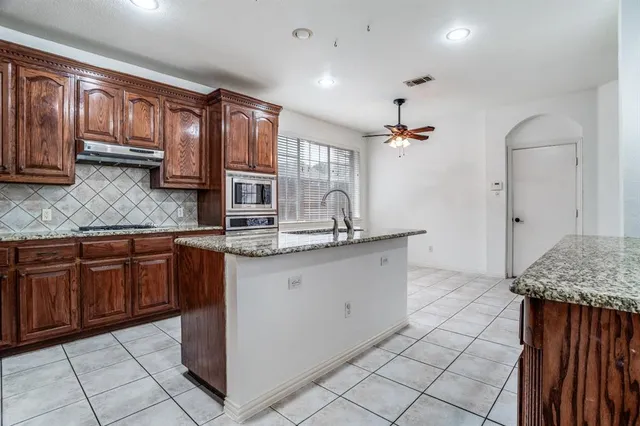 a kitchen with granite countertop a sink and cabinets