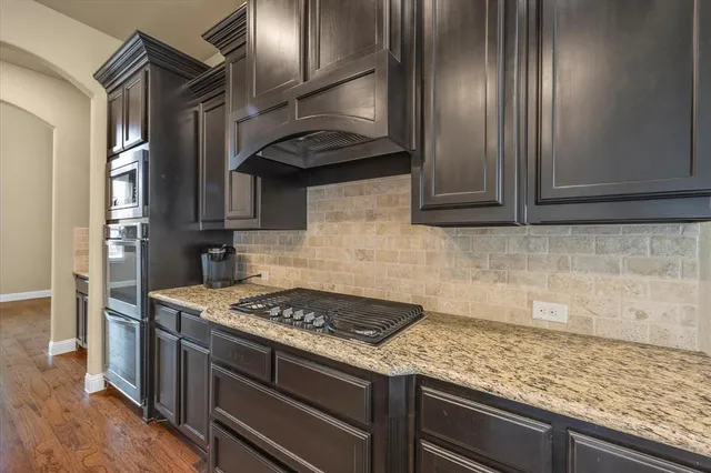 a kitchen with granite countertop cabinets stainless steel appliances and a counter space