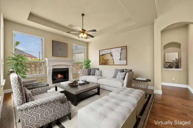 a view of an empty room with wooden floor fireplace and a window