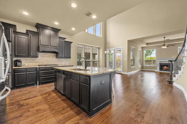 a kitchen with stainless steel appliances granite countertop wooden cabinets a stove top oven a sink and dishwasher