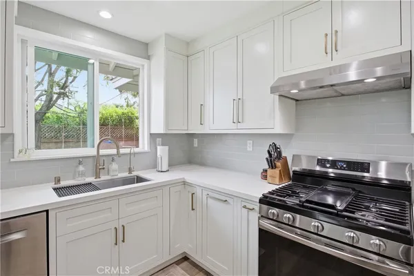 a kitchen with stainless steel appliances granite countertop a sink stove and cabinets