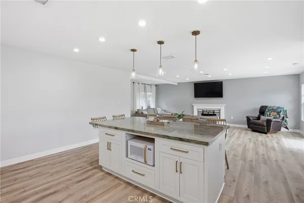 a kitchen with stainless steel appliances granite countertop a sink and a wooden floor