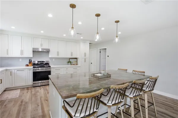 a kitchen with a dining table chairs and white cabinets