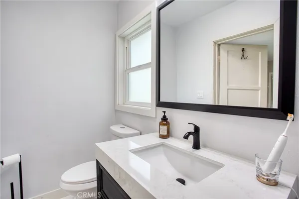 a bathroom with a sink a toilet and a window