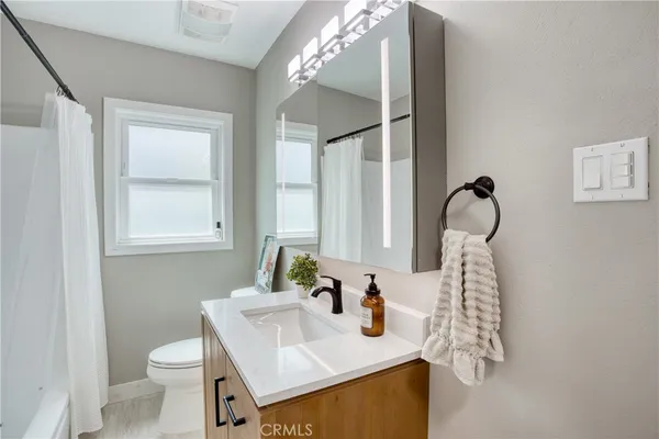a bathroom with a sink toilet and mirror