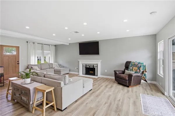 a living room with furniture a fireplace and a flat screen tv