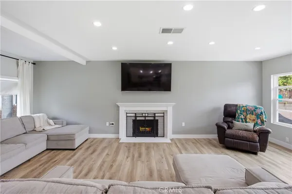 a living room with furniture a fireplace and a flat screen tv