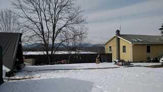 a front view of house with yard and trees around