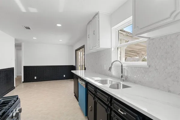 a kitchen with a sink appliances and a window
