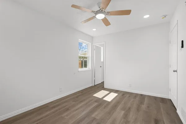an empty room with a window and wooden floor