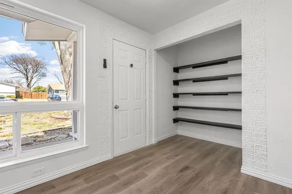 a view of a room with wooden floor and windows