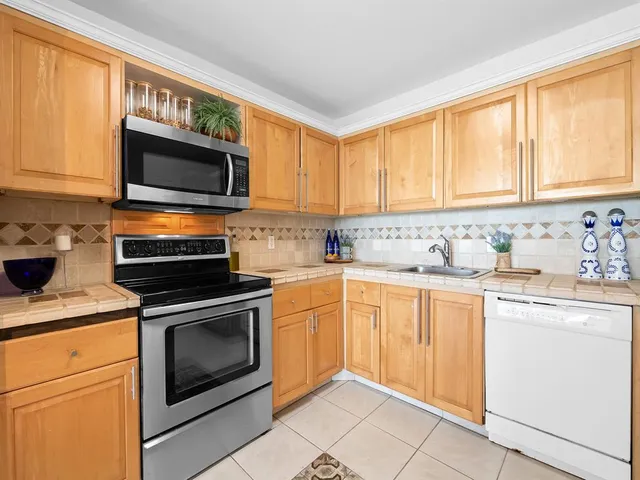 a kitchen with stainless steel appliances granite countertop a stove microwave and sink