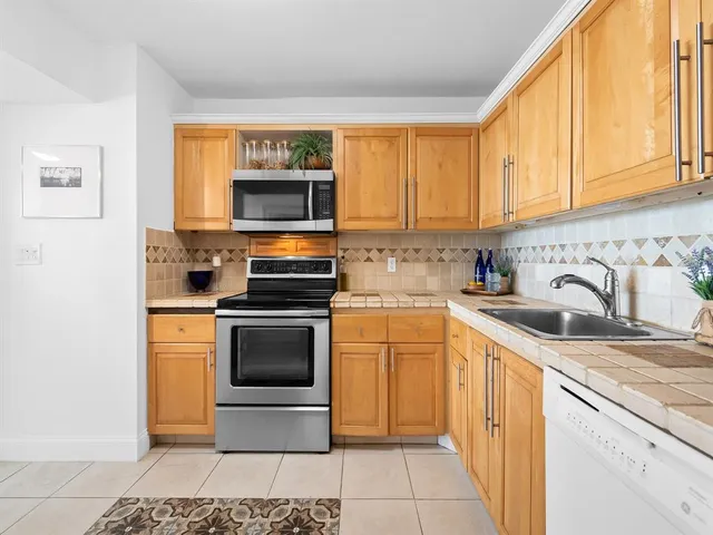 a kitchen with stainless steel appliances granite countertop a stove microwave and sink