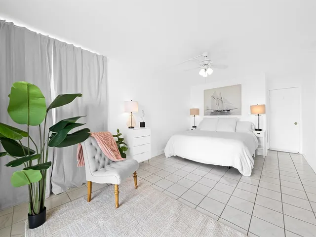 a bedroom with a bed lamps and chairs