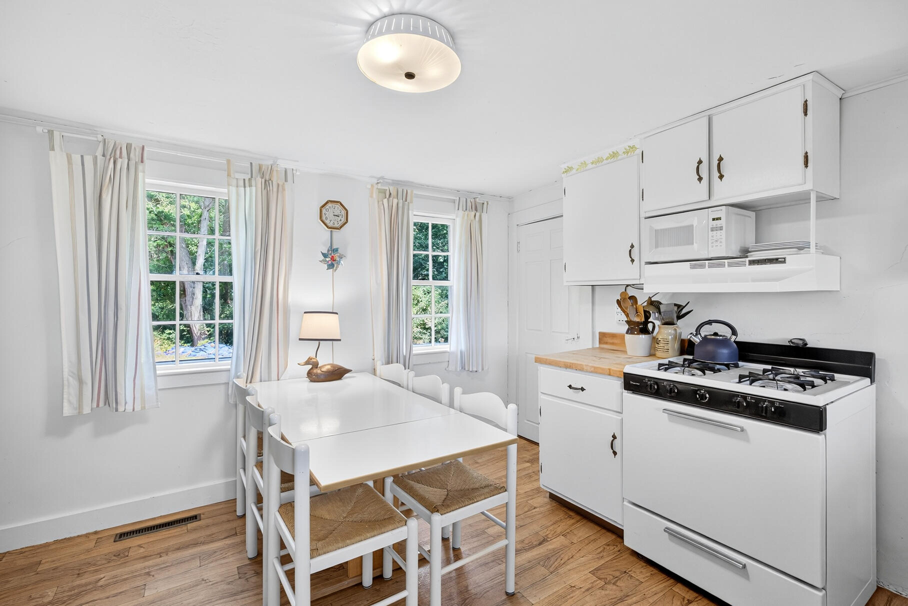10 Cartway South Eastham, MA 02642 - Photo 14 of 52 a kitchen with stainless steel appliances granite countertop a stove a sink dishwasher and white cabinets with wooden floor