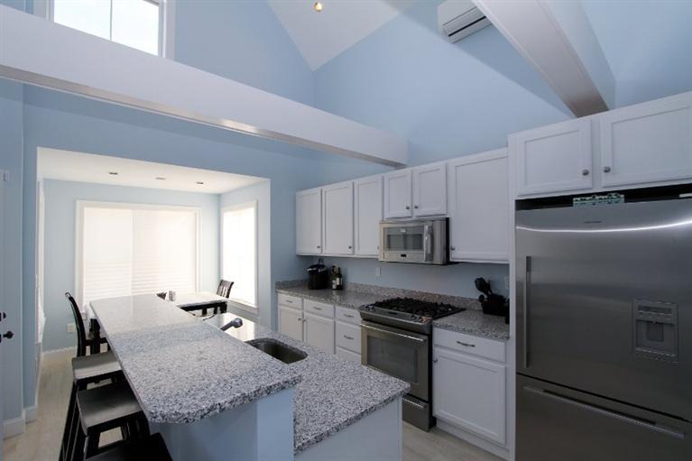 61 Old Wharf Road, Unit 1 Dennis Port, MA 02639 - Photo 8 of 34 a kitchen with granite countertop a refrigerator stove and sink
