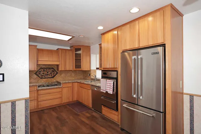 a kitchen with stainless steel appliances granite countertop a refrigerator and a sink