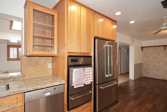 a kitchen with stainless steel appliances granite countertop a refrigerator and a sink