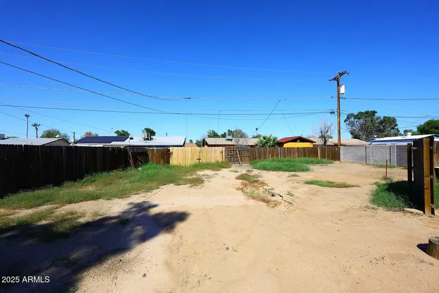 a view of a yard with wooden fence