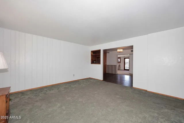 a view of a livingroom with an empty space and a window