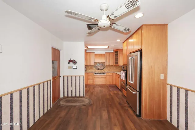 a view of a hallway with wooden floor and chandelier fan