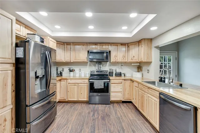 a kitchen with granite countertop a refrigerator stove top oven and sink