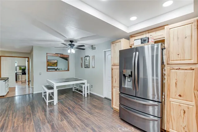 a kitchen with stainless steel appliances granite countertop a refrigerator microwave and wooden floor