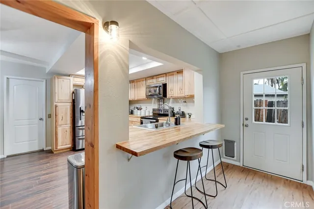 a kitchen with kitchen island a counter top space a sink stainless steel appliances and cabinets