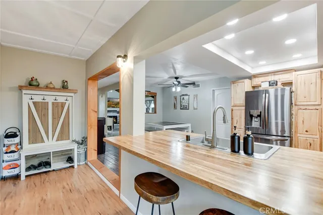 a room with stainless steel appliances kitchen island granite countertop a table chairs and a refrigerator